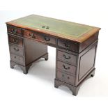 A reproduction mahogany pedestal desk inset gilt-tooled green leather cloth, fitted with an
