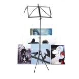A black metal finish fold-away sheet music stand; & eight photographs on faux canvas.