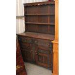 A reproduction oak dresser the upper part fitted two open shelves, the base fitted two frieze