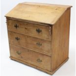 A pine bureau with fitted interior enclosed by fall-front above three long graduated drawers, & on