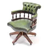 A reproduction buttoned & brass studded green leather swivel desk chair.