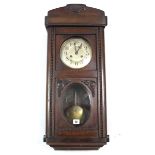 A mid-20th century wall clock with silvered dial, striking movement, & in walnut case enclosed by