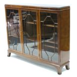 An Edwardian mahogany bookcase with nine adjustable shelves enclosed b by three glazed doors, & on