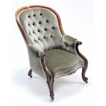 A Victorian walnut frame easy chair with buttoned back & arms & with sprung seat upholstered pale