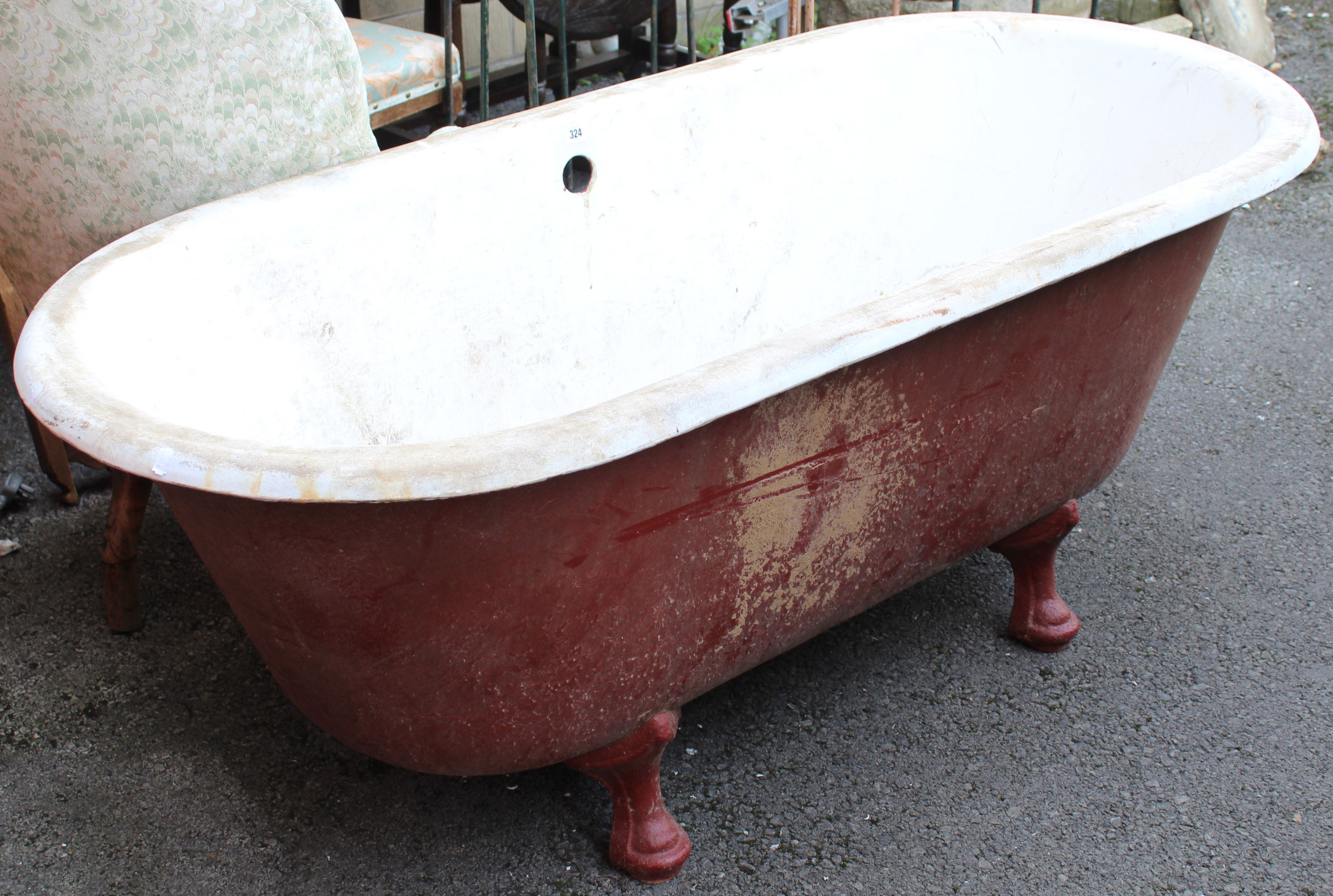 A cast-iron free-standing roll-top bath on four short cabriole legs, 64” long x 25” high.