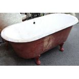 A cast-iron free-standing roll-top bath on four short cabriole legs, 64” long x 25” high.