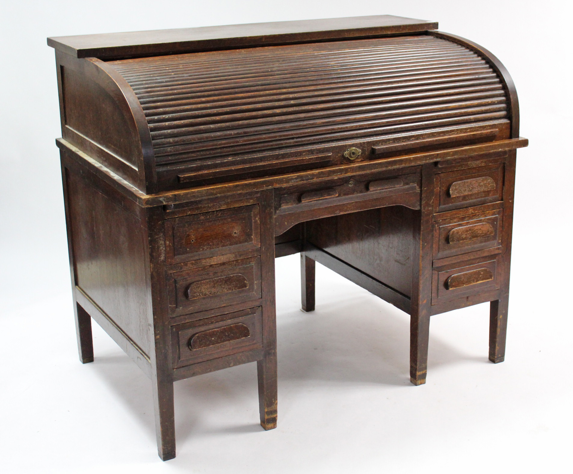 An early 20th century oak roll-top desk with fitted interior enclosed by tambour shutter, fitted