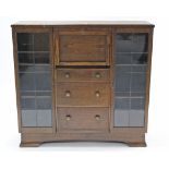 A mid-20th century oak side cabinet, with fitted interior to centre enclosed by fall-front above
