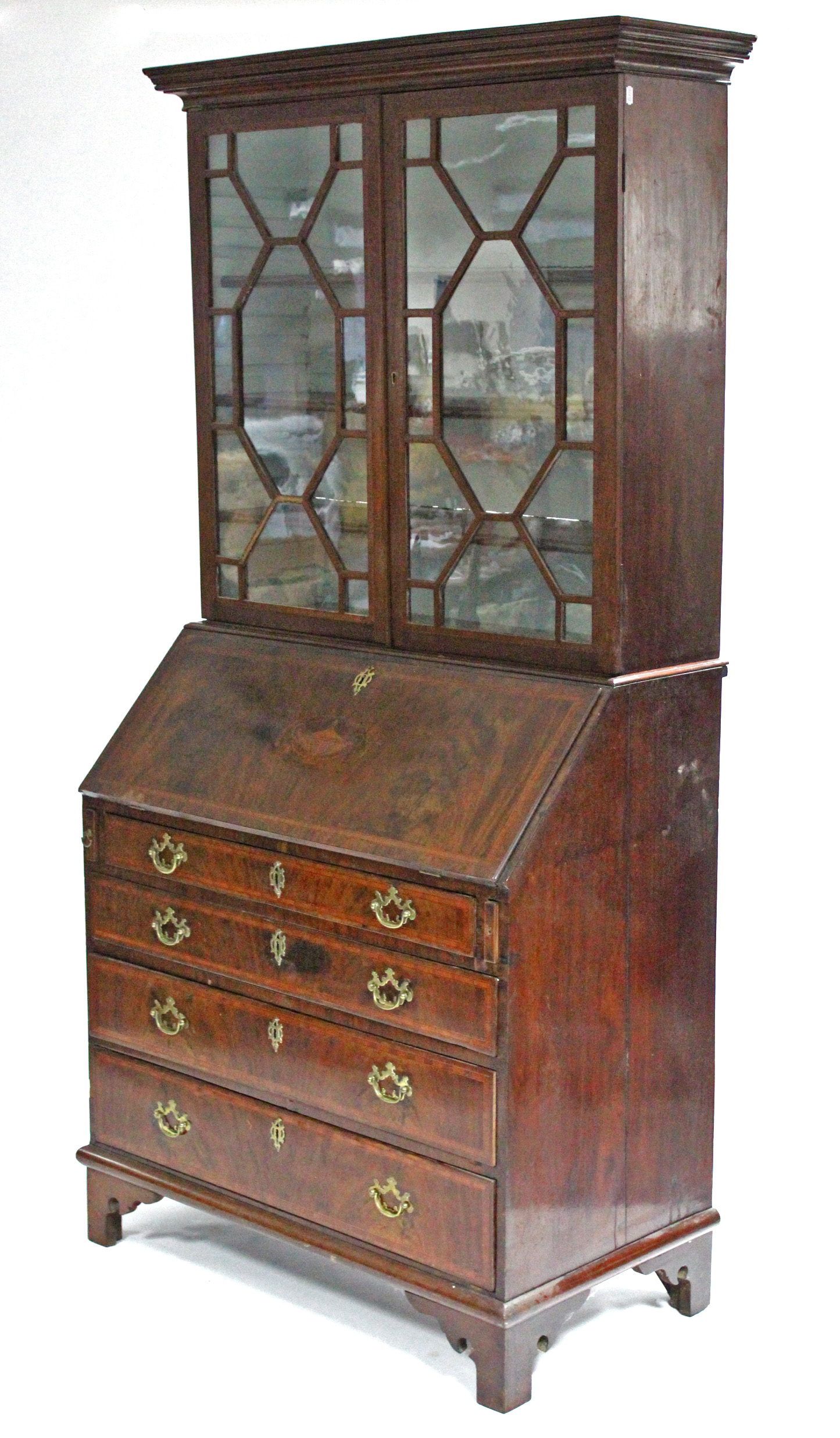 A late 18th century figured mahogany & crossbanded bureau-bookcase, with moulded cornice above three