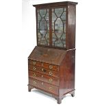 A late 18th century figured mahogany & crossbanded bureau-bookcase, with moulded cornice above three