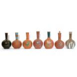 Seven various terracotta & pottery bottle vases, six with floral decoration, one with dark green