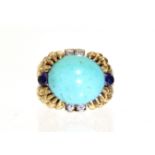 A TURQUOISE, DIAMOND, & SAPPHIRE RING, the large oval cabochon turquoise bordered by two pairs of