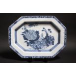 An 18th century Irish delft meat plate, decorated with a vase of peacock feathers on a rockwork