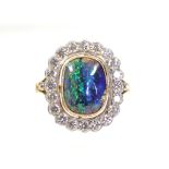 A BLACK OPAL & DIAMOND RING, the cushion-shaped cabochon opal measuring 11mm x 8.5mm set within a
