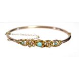 A 9ct. gold stiff hinged hollow bangle set turquoise beads & seed pearls. (5.6gm gross).