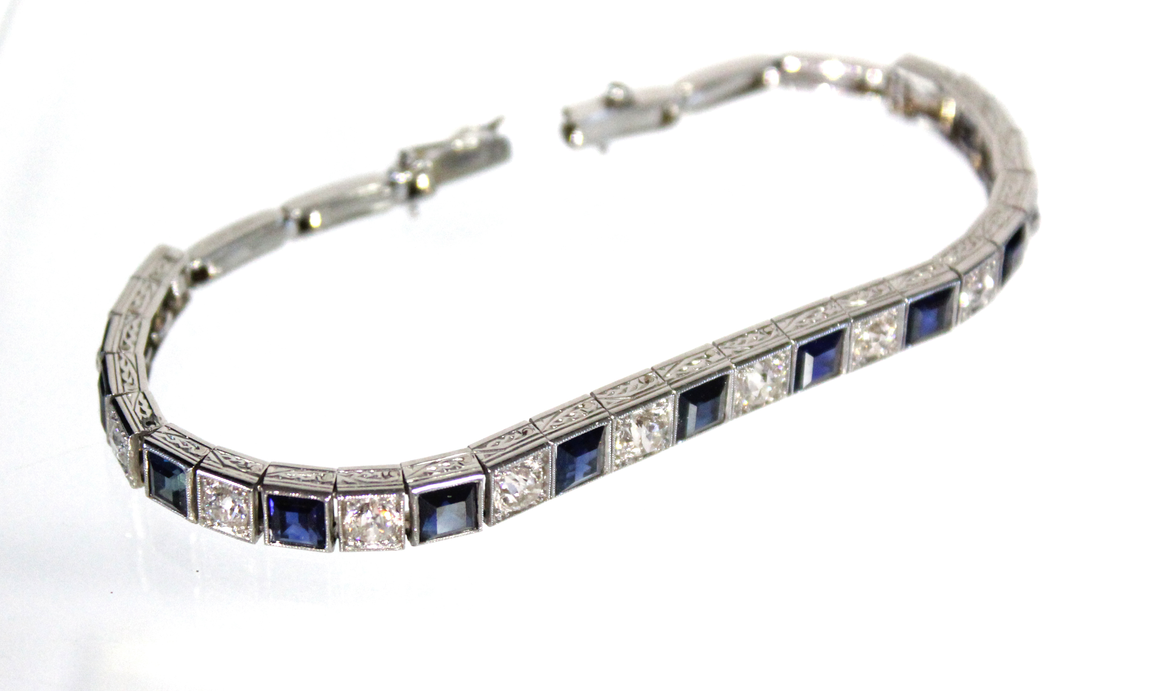 AN ART DECO PLATINUM, DIAMOND, & SAPPHIRE EXPANDING BRACELET, the thirteen graduated pavé-set - Image 6 of 7