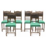 A set of six continental-style carved oak dining chairs with brass-studded leather backs on