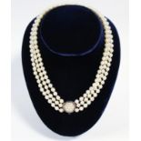 A three-strand choker of Mikimoto cultured pearls, with antique gold, blue enamel, & pearl-set