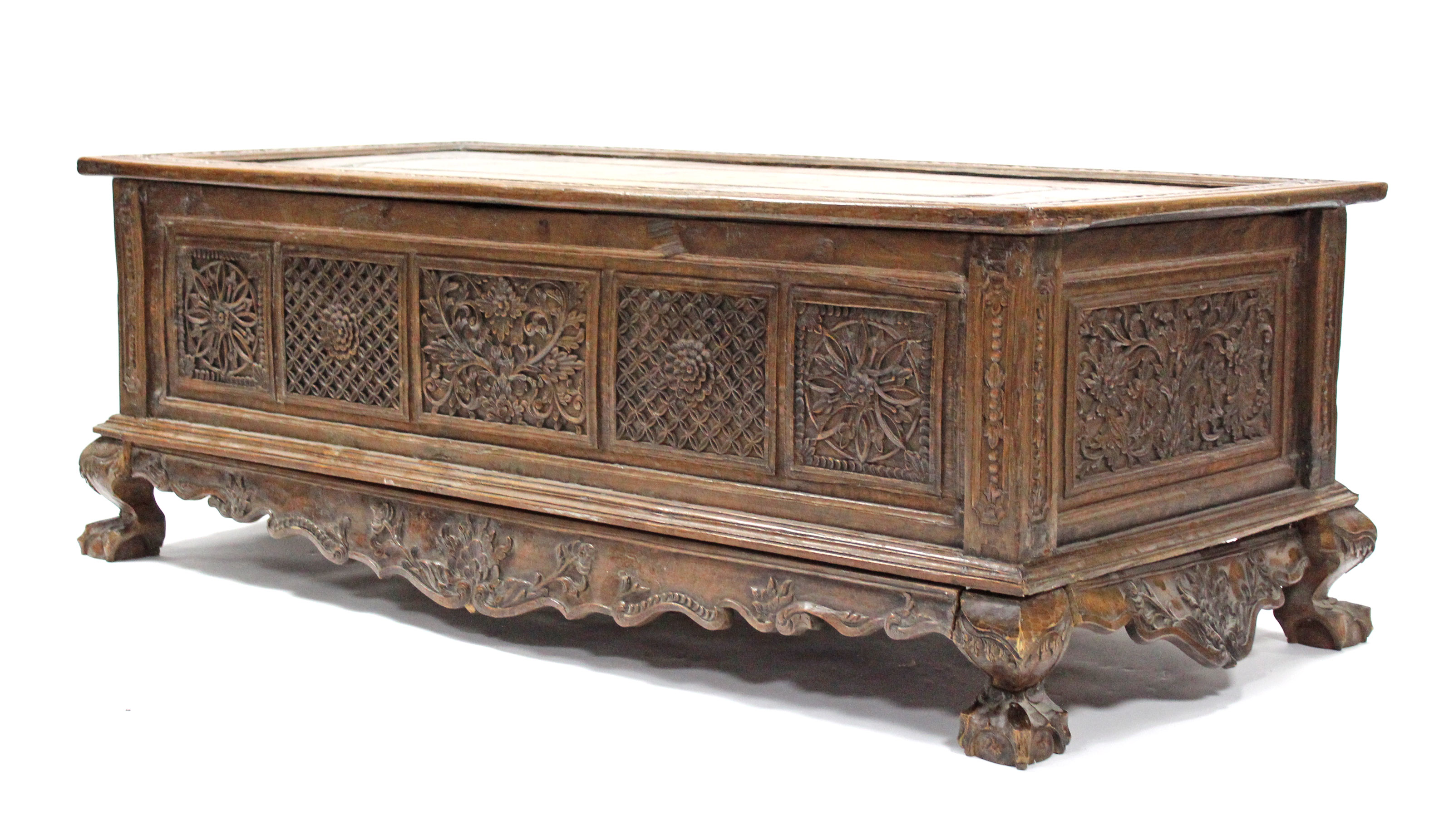 A 19th century INDONESIAN SOLID HARDWOOD CHEST, profusely carved to all sides with floral &