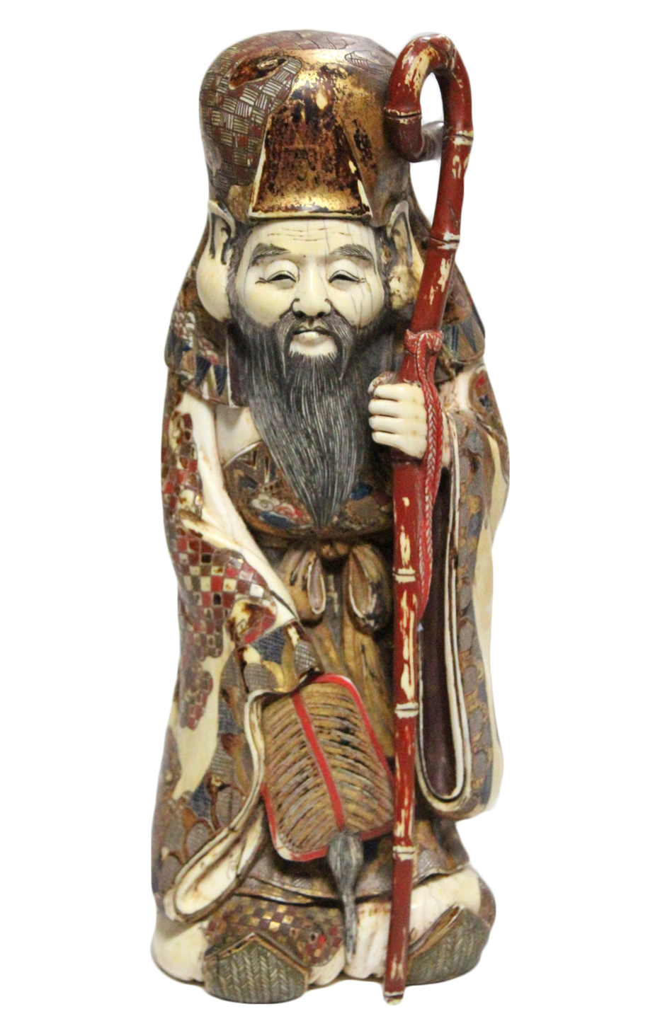 A JAPANESE CARVED IVORY LARGE OKIMONO OF FUKUROKUJU, dressed in flowing robes holding a fan & a