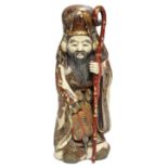 A JAPANESE CARVED IVORY LARGE OKIMONO OF FUKUROKUJU, dressed in flowing robes holding a fan & a