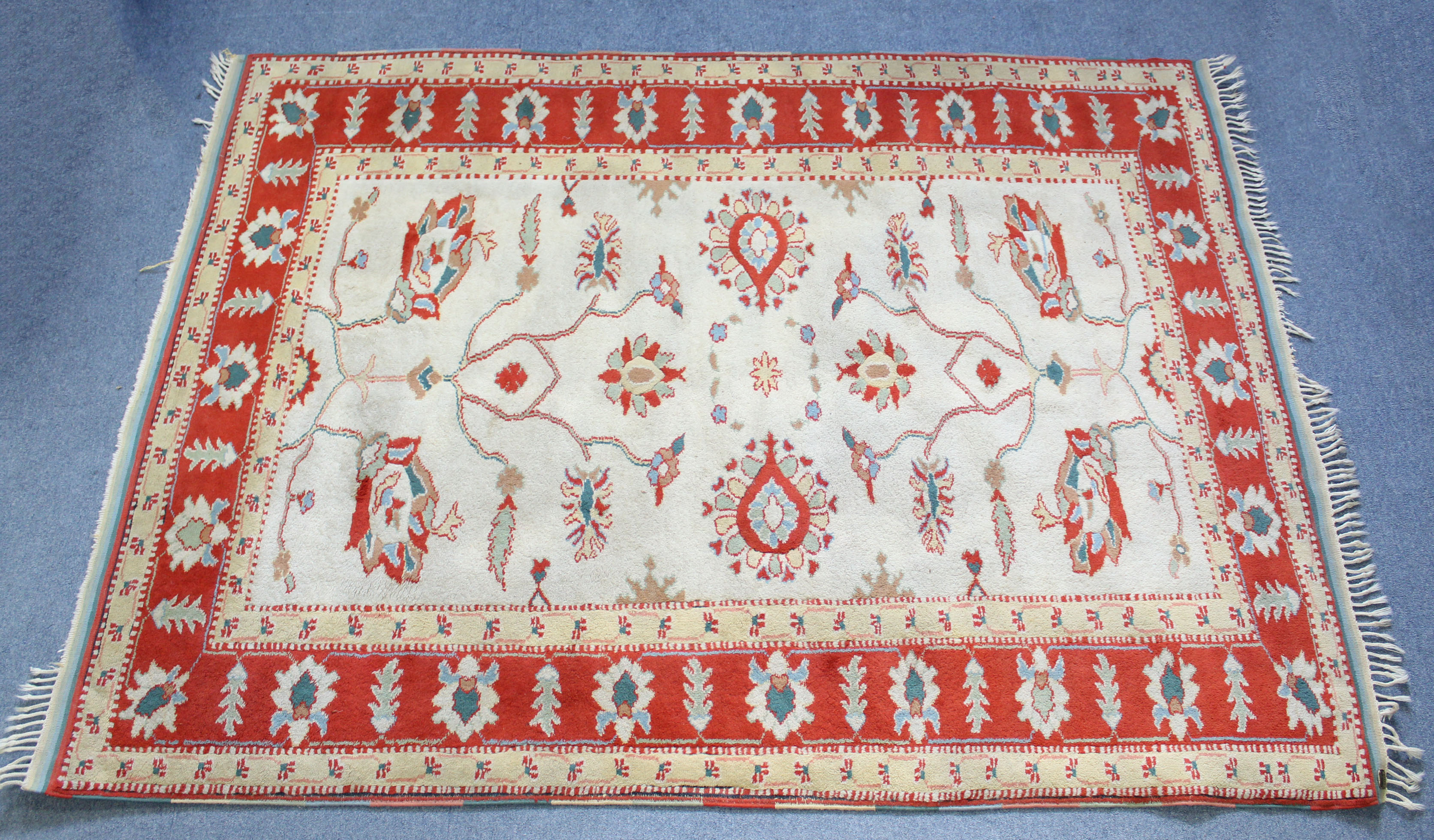 A Turkish Konya rug of ivory ground, with central foliate design within a rust-red border; 74” x