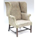 A George III wing-back armchair, the sprung seat, padded back & curved arms upholstered multi-