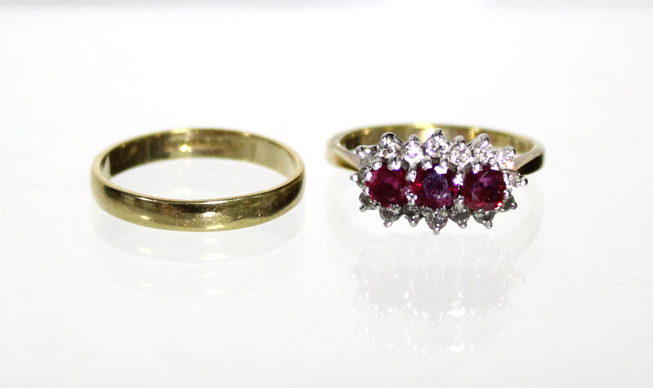 An 18ct. gold ring set three rubies within a border of small diamonds (Size: M); & an 18ct. gold - Image 2 of 5