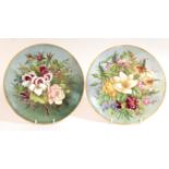 A pair of Coalport porcelain dessert plates, each decorated with a bouquet of flowers on a blue/