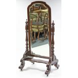 A mid/late-19th century mahogany cheval mirror, the rectangular bevelled plate with shaped top, & on