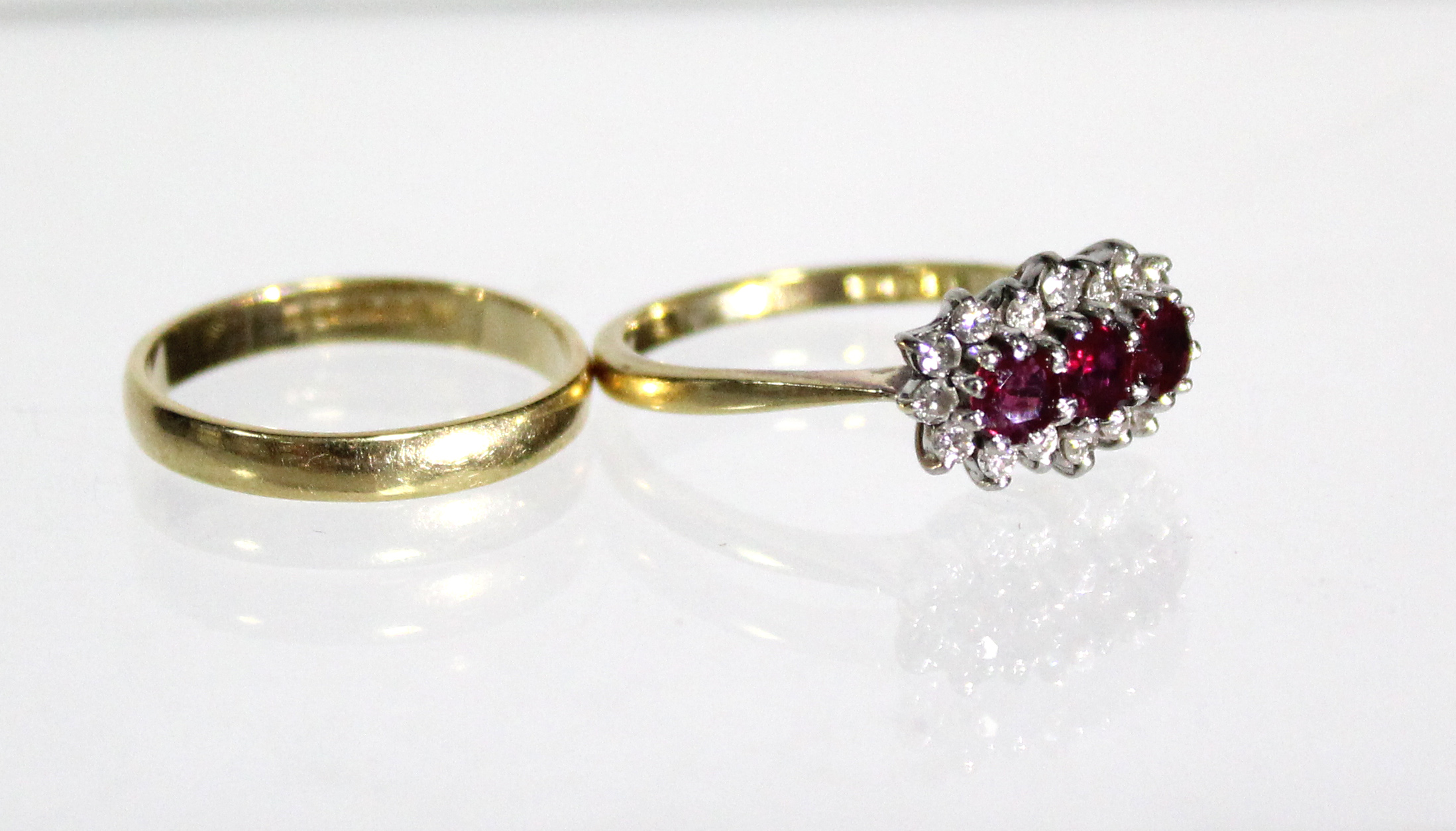 An 18ct. gold ring set three rubies within a border of small diamonds (Size: M); & an 18ct. gold - Image 3 of 5