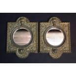 A pair of continental-style embossed brass frame wall mirrors, with circular bevelled plates; each