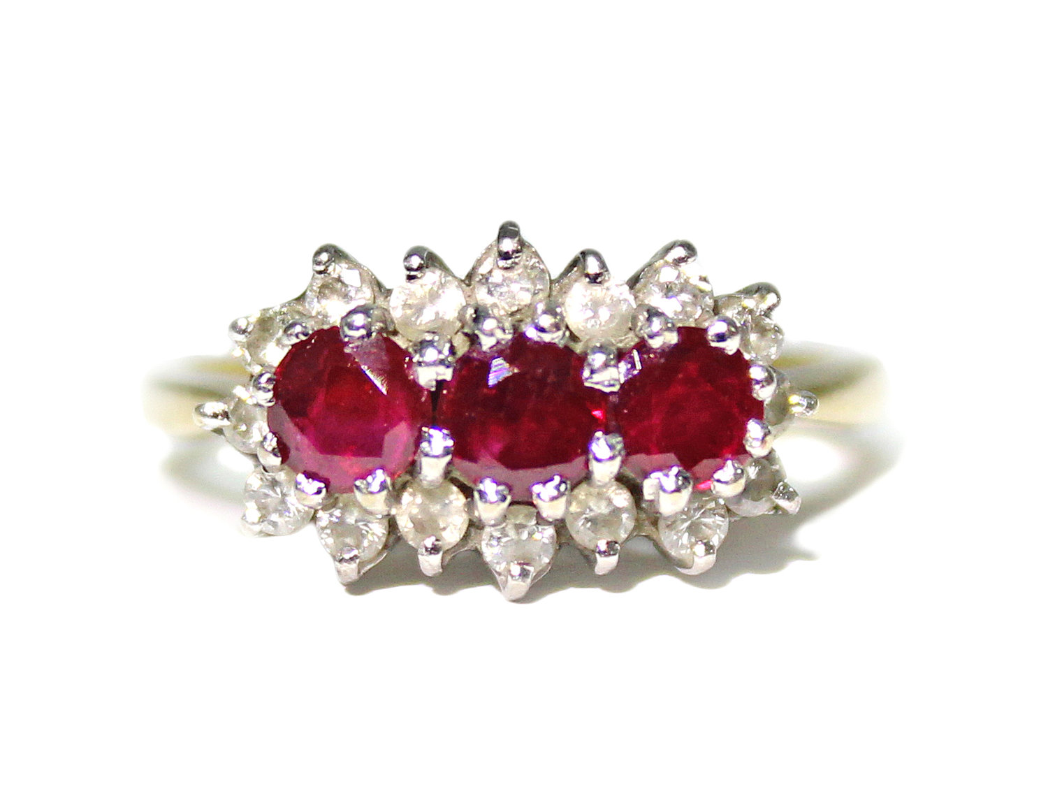 An 18ct. gold ring set three rubies within a border of small diamonds (Size: M); & an 18ct. gold