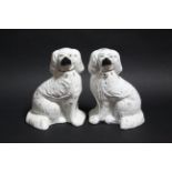 A pair of Staffordshire seated spaniel ornaments; 10” high. (some wear to decoration).