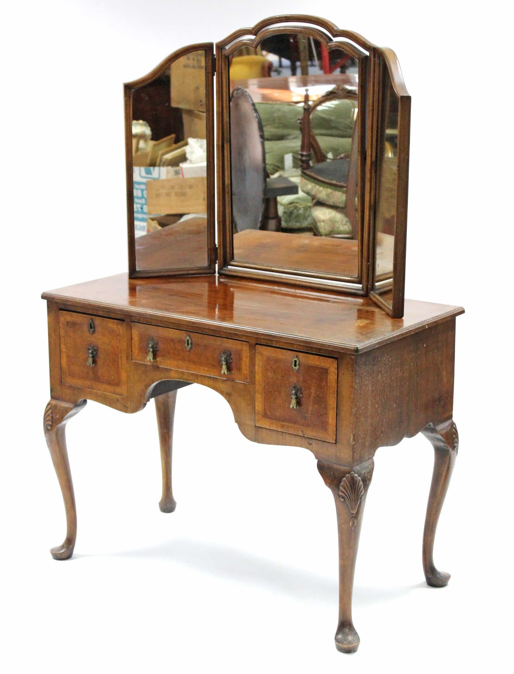 An 18th century-style walnut dressing table with triple-panel mirror back, fitted three frieze