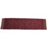 A Meshwari runner of dark blue & crimson ground with all-over repeating geometric design; 25” wide x