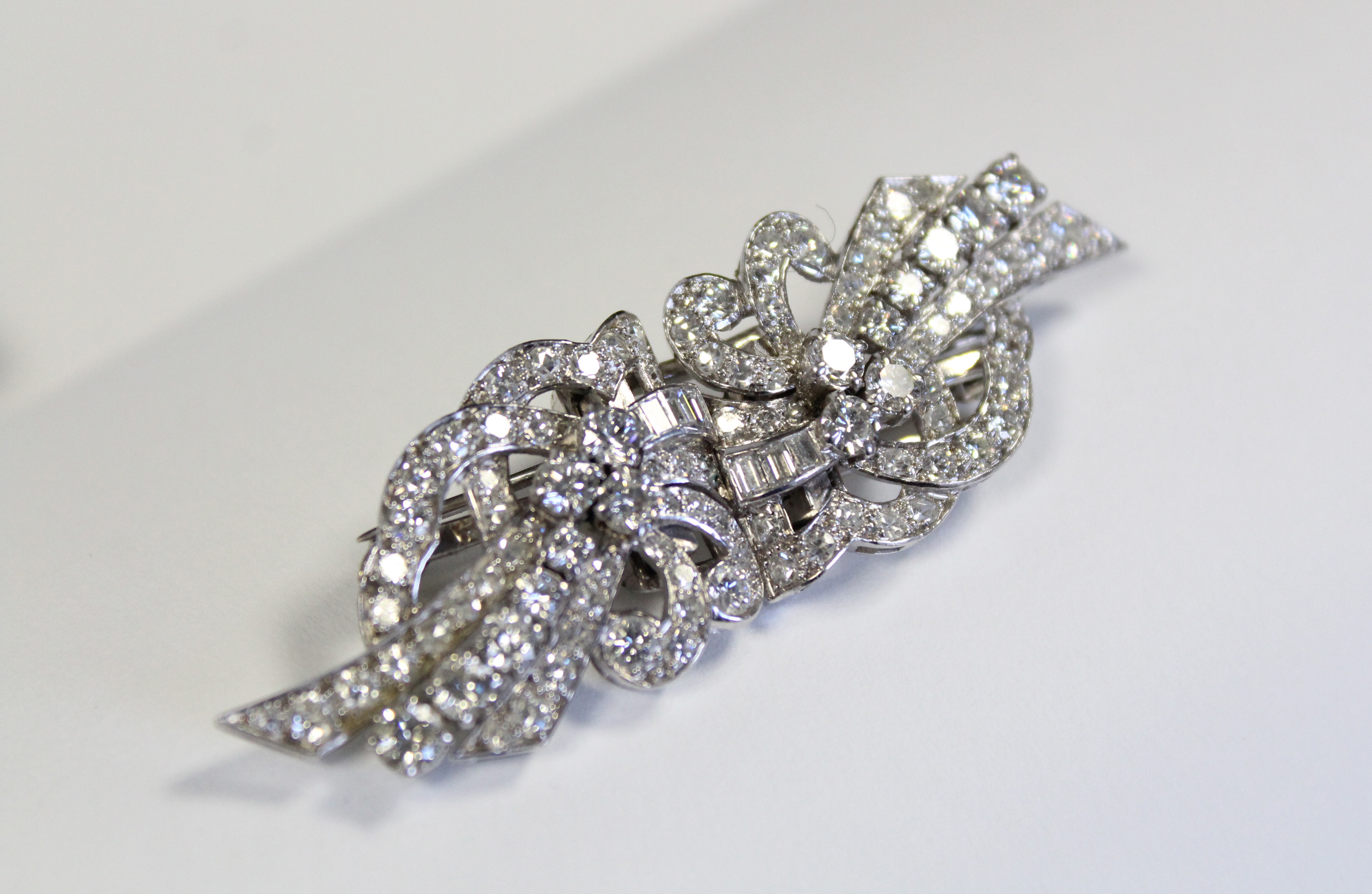 A PLATINUM & DIAMOND DOUBLE-CLIP BROOCH of scroll design, set approximately 102 round & baguette-cut - Image 2 of 4