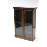 A mahogany small standing bookcase with three adjustable shelves enclosed by pair of glazed doors, &