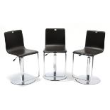 A set of three chrome-finish & brown leatherette swivel bar stools with rise & fall action.