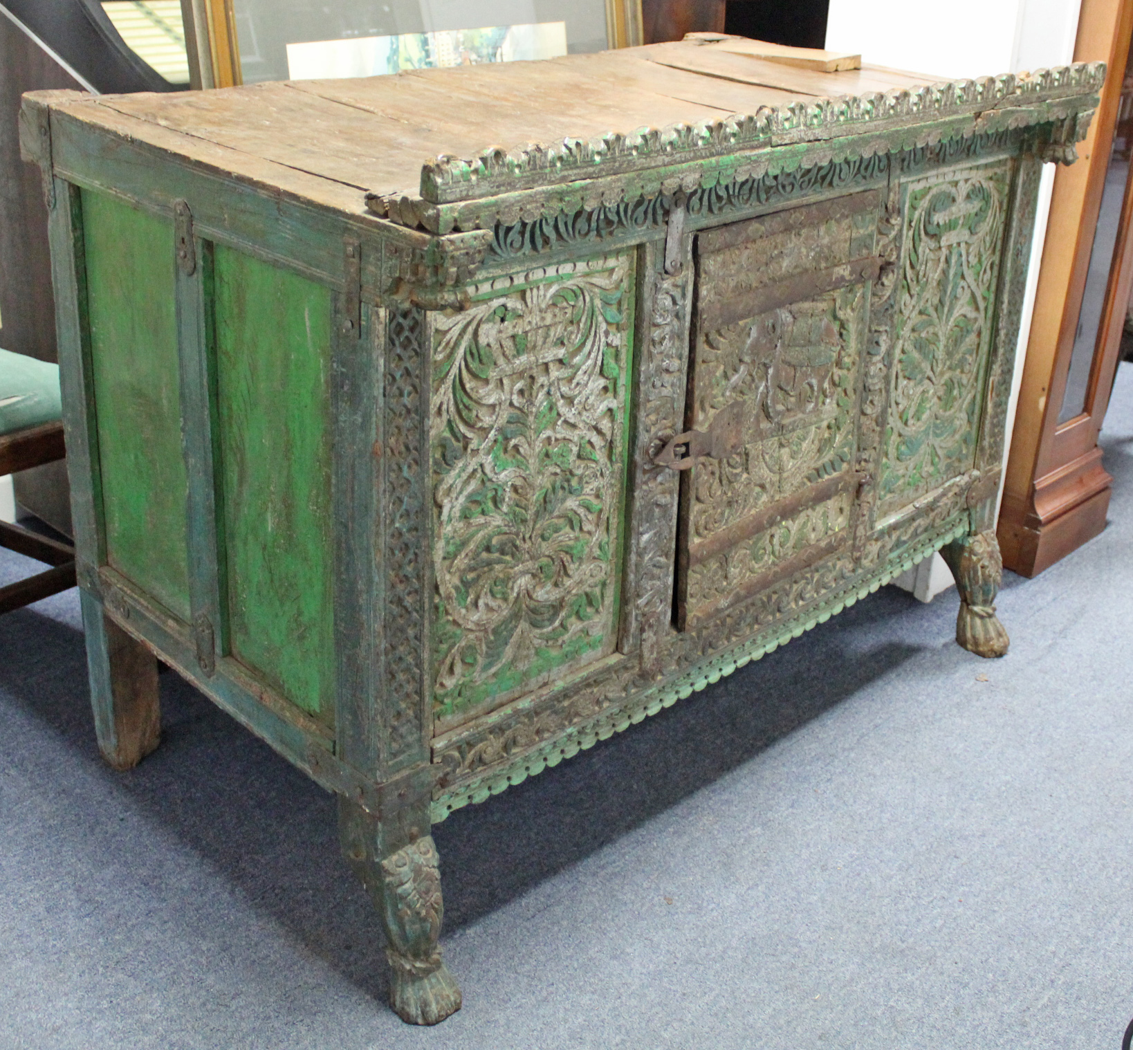 AN ANTIQUE INDIAN GREEN & GREY PAINTED & CARVED HARDWOOD LOW CABINET, ENCLOSED BY CARVED PANEL DOOR,