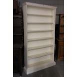 A white painted wooden tall standing seven-tier open bookcase on plinth base, 45” wide x 80½” high.
