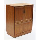 A G-Plan teak cabinet enclosed by pair of panel doors above a sliding door, & on plinth base, 32”