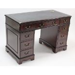 A reproduction mahogany break-front pedestal desk, inset gilt-tooled green leather, fitted with an