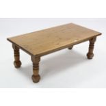 A large pine rectangular low coffee table on four turned legs, 52” x 27”.