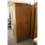 A pine wardrobe enclosed by pair of fielded panel doors, & on shaped plinth base, 35½” wide x 70½”