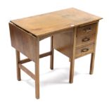 A light oak typist’s desk, the right-hand side fitted brushing slide above three long drawers, &