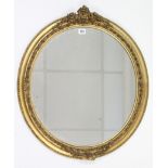 A gilt frame oval wall mirror with raised foliate border, 26½” x 23½”.