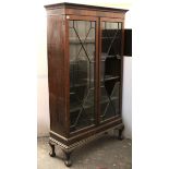 A late 19th/early-20th century mahogany tall bookcase with four adjustable shelves enclosed by