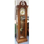 An Empire Clock Co. reproduction three-train longcase clock with silvered & brass dial; & in