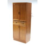 A G-Plan teak tall cocktail cabinet, enclosed by pair of panel doors above a brushing slide & a long